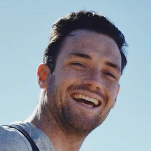 Man smiling outdoors, showcasing healthy gums and teeth—ideal for comprehensive oral care routines at home or travel.