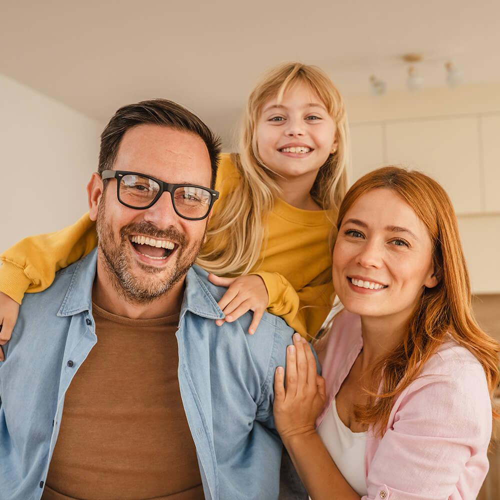 Happy family smiling together, promoting healthy smiles and comprehensive oral care routines at home.